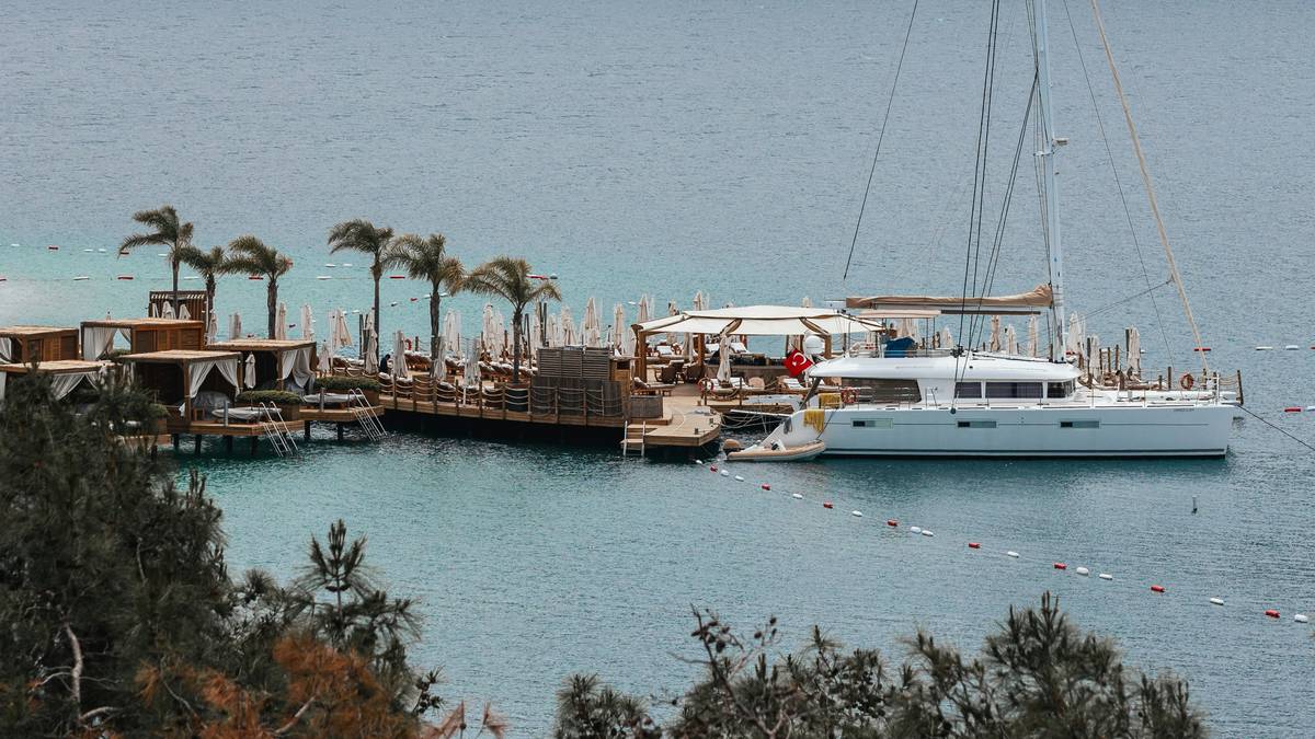Yacht owner reviewing elite marine coverage plans document on deck with broker